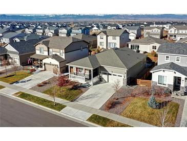 Charming one-story home with a covered porch, attached garage, and mountain views at 802 Eva Peak Dr, Erie, CO 80516