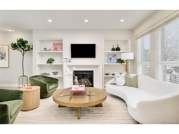 Bright living room featuring a fireplace with built-in shelves and stylish, neutral decor at 3221 Perry St, Denver, CO 80212