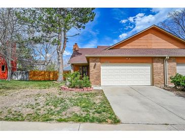 Inviting brick home with a two-car garage and a well-maintained front yard at 13028 Garfield Dr, Thornton, CO 80241