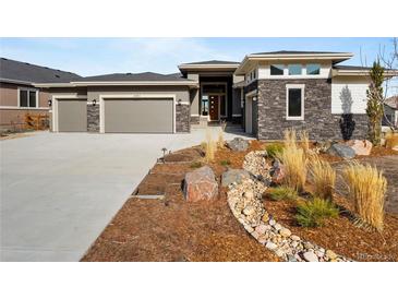 Stunning single-Gathering home with stone accents, three-car garage, and beautifully landscaped front yard at 4585 Mesa Top Dr, Monument, CO 80132