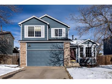 Two-story house with gray siding, brick accents, and a two-car garage at 4443 E Bennington Ave, Castle Rock, CO 80104