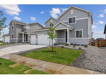Charming two-story home featuring a two-car garage, manicured lawn, and welcoming entrance at 14400 Heritage Dr, Mead, CO 80504
