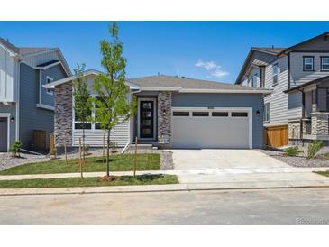 Charming single-Gathering home with a two-car garage, stone accents, and fresh landscaping at 9091 Telluride Ct, Commerce City, CO 80022