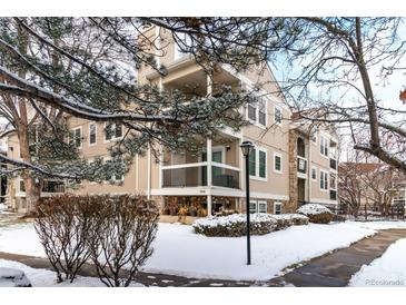 Tan multi-unit building with snow-covered landscaping at 5341 W 76Th Ave # 221, Arvada, CO 80003