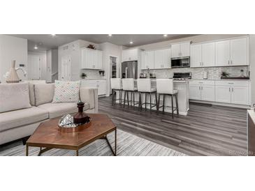 Bright, modern kitchen with white cabinets, stainless steel appliances, and a large island with bar seating at 1126 S Yampa St, Aurora, CO 80017