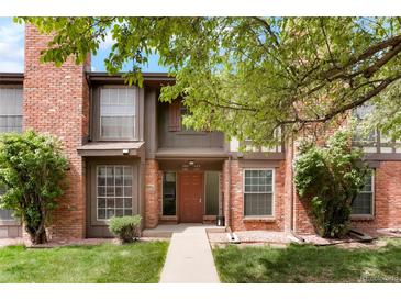 Charming townhome with a red brick exterior and a well-maintained front lawn at 3855 S Monaco St # 166, Denver, CO 80237