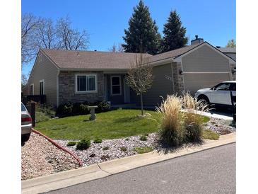 Charming single-story home with stone accents, well-maintained lawn, and attached two-car garage at 9960 Garland Ln, Broomfield, CO 80021