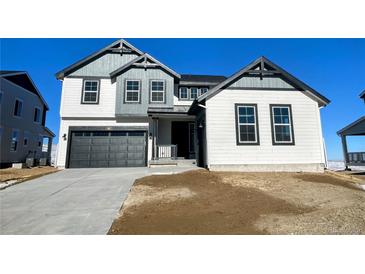 Two-story house with gray and white siding, a dark gray garage door, and a landscaped yard at 907 Congress Pl, Elizabeth, CO 80107