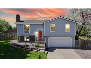 Charming two-story home featuring a red front door, well-manicured lawn, and blooming trees creating curb appeal at 10950 Tennyson Ct, Westminster, CO 80031