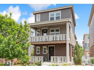 Charming two-story home with a brick facade and a welcoming front porch on both the first and second level at 2395 S Troy Ct, Aurora, CO 80014