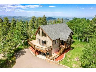 Beautiful exterior with large deck and stunning mountain views and a well-maintained landscaped yard at 10436 Jeanette Ct, Morrison, CO 80465
