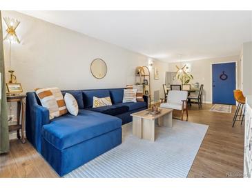 Cozy living room featuring a stylish blue sectional sofa, hardwood floors, and modern decor at 2 N Adams St # 108, Denver, CO 80206