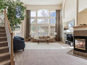 Bright, spacious living room with a large window, fireplace, and comfortable seating arrangement at 7858 Oban Ct, Lone Tree, CO 80124