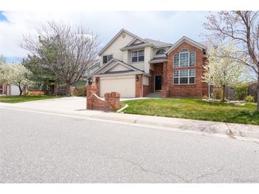 Charming two-story home with a well-manicured lawn and brick accents at 18112 E Dorado Ave, Centennial, CO 80015