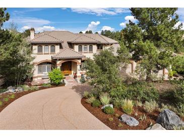 Stunning two-story home featuring a tile roof, beautiful landscaping, and a private circular driveway at 145 Capulin Pl, Castle Rock, CO 80108