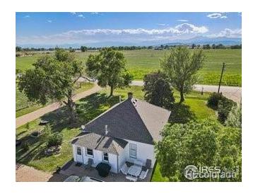 Charming home featuring a well-maintained roof, lush landscaping, and scenic views of the surrounding greenery and mountains at 14798 N 115Th St, Longmont, CO 80504