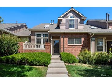 Attractive townhome featuring brick accents, a covered entry, and well-maintained landscaping at 8105 E Bayaud Ave, Denver, CO 80230