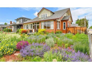 Charming brick home featuring a vibrant and colorful garden in the front yard at 2096 S Logan St, Denver, CO 80210