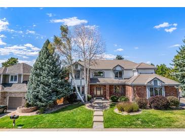 Two-story home with brick and siding exterior, landscaping, and a paved walkway at 5594 S Jasper Way, Centennial, CO 80015