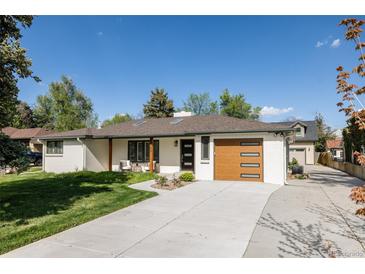 Ranch style home with white painted brick, updated front door and modern garage door at 3540 Everett St, Wheat Ridge, CO 80033