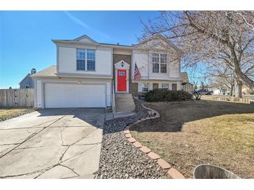 Charming two-story home features a bright red front door and attached two-car garage at 11278 W 103Rd Dr, Broomfield, CO 80021