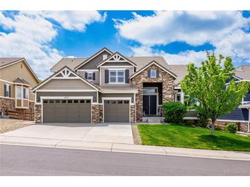 Charming two-story home with a stone and siding exterior, two-car garage, and well-manicured lawn at 5010 Persimmon Ln, Castle Rock, CO 80109