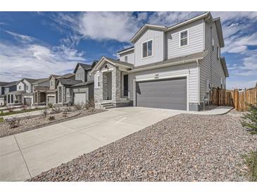 Charming two-story home showcasing professional landscaping, a gray color scheme, and an attached two-car garage at 4903 Basalt Ridge Cir, Castle Rock, CO 80108