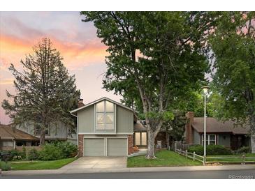 Charming two-story home boasts mature trees, a well-maintained lawn and a two car garage at 12466 E Amherst Cir, Aurora, CO 80014