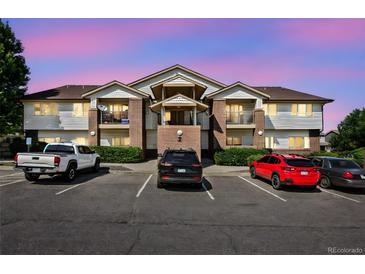 Condo exterior featuring brick accents, siding, multiple balconies, and convenient parking spaces at 875 E 78Th Ave # 9-2, Denver, CO 80229