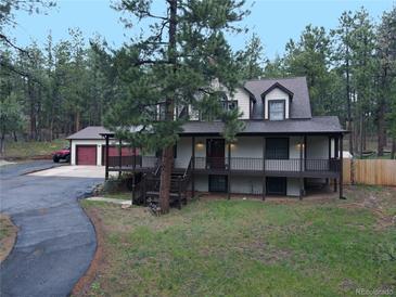 Charming two-story home with a spacious front porch and mature trees at 4305 Red Rock Dr, Larkspur, CO 80118