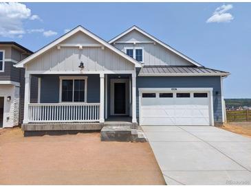 Charming single-Gathering home with a covered porch and a two-car garage, painted in pleasing neutral colors at 8326 Cokedale Cir, Littleton, CO 80125