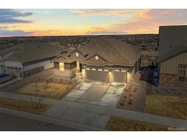 Beautiful, ranch-style home featuring a three-car garage and professional landscaping at 8784 S Riviera Ct, Aurora, CO 80016