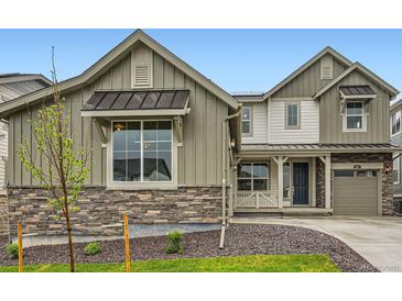Charming two-story home featuring stone accents, a dark door, and a well-maintained front yard at 595 Twilight St, Erie, CO 80516