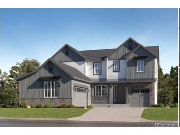 New construction home boasts modern architectural design, a manicured lawn, and a two-car garage at 595 Twilight St, Erie, CO 80516