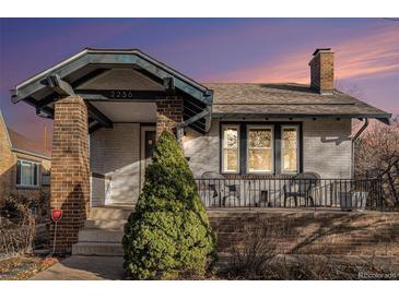 Charming white brick bungalow with front porch and landscaping at 2236 Jasmine St, Denver, CO 80207