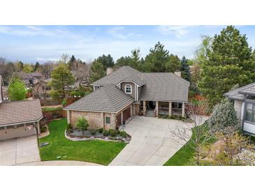 Stunning home exterior with brick accents, mature trees, and a well-manicured front yard at 7836 S Fairfax Ct, Centennial, CO 80122