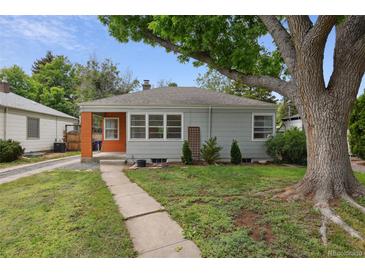 Charming single-story home with a gray exterior, orange entryway, and mature tree shading the front yard at 2709 S Franklin St, Denver, CO 80210