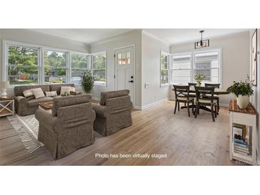 Bright living room featuring hardwood floors, a large window, and neutral decor at 2709 S Franklin St, Denver, CO 80210