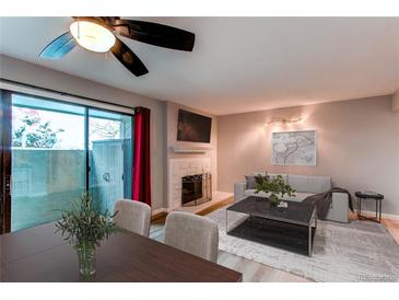 Inviting living room features a cozy fireplace, sliding glass door to patio and contemporary décor at 14100 E Temple Dr # W01, Aurora, CO 80015