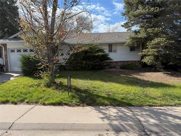 Charming ranch home with a well-maintained lawn, mature trees, and an attached garage, perfect for suburban living at 2991 S Whiting Way, Denver, CO 80231