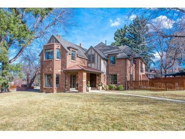 Charming two-story brick home with a manicured front lawn and a welcoming covered entrance at 290 Dexter St, Denver, CO 80220