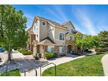 Beautiful two-story townhome featuring stone accents, manicured lawn, and a welcoming facade at 494 Black Feather Loop # 108, Castle Rock, CO 80104