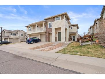 Charming two-story townhome featuring a balcony, attached garage, and inviting front entrance at 13000 W Grant Cir # C, Thornton, CO 80241
