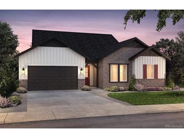 Charming home with a two-car garage, brick and white siding, and well-manicured landscaping at 22077 E Rockinghorse Pkwy, Aurora, CO 80016