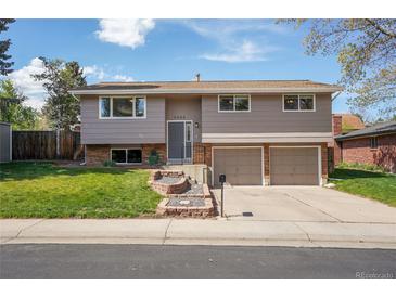 Charming two-story home with a manicured lawn, beautiful terraced garden, and an attached two-car garage at 9099 W Harvard Pl, Lakewood, CO 80227