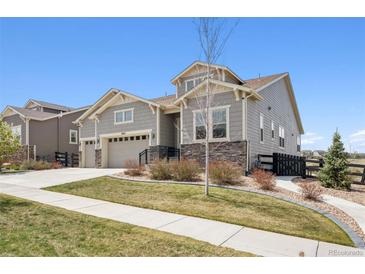 Charming two-story home with stone accents, manicured lawn, and a two-car garage at 8621 S De Gaulle Ct, Aurora, CO 80016