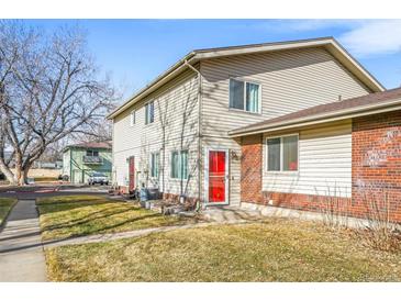 Traditional townhome with a brick accent, trimmed lawn, and mature shade tree at 3355 S Flower St # 59, Lakewood, CO 80227