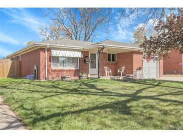 Charming brick home with a well-manicured lawn and inviting front porch, perfect for relaxing at 3022 Blackhawk St, Aurora, CO 80011