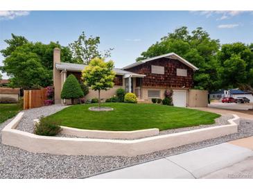 Charming home featuring a well-manicured lawn, stone accents, mature trees, and a brick and wood exterior at 147 Wallace St, Northglenn, CO 80234