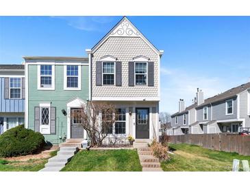 Charming townhome featuring a scalloped facade, lush lawn and inviting entryway with well-maintained landscaping at 10715 Foxwood Ct, Parker, CO 80138
